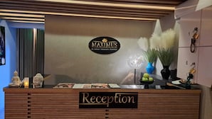 En receptionsdisk med et skilt, der viser 'MAXIMUS' og 'Reception'.