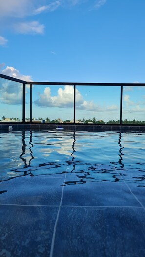 A swimming pool with a clear view of the sky and distant buildings.