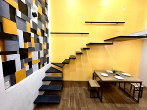Un interior moderno con una escalera que lleva a un comedor.