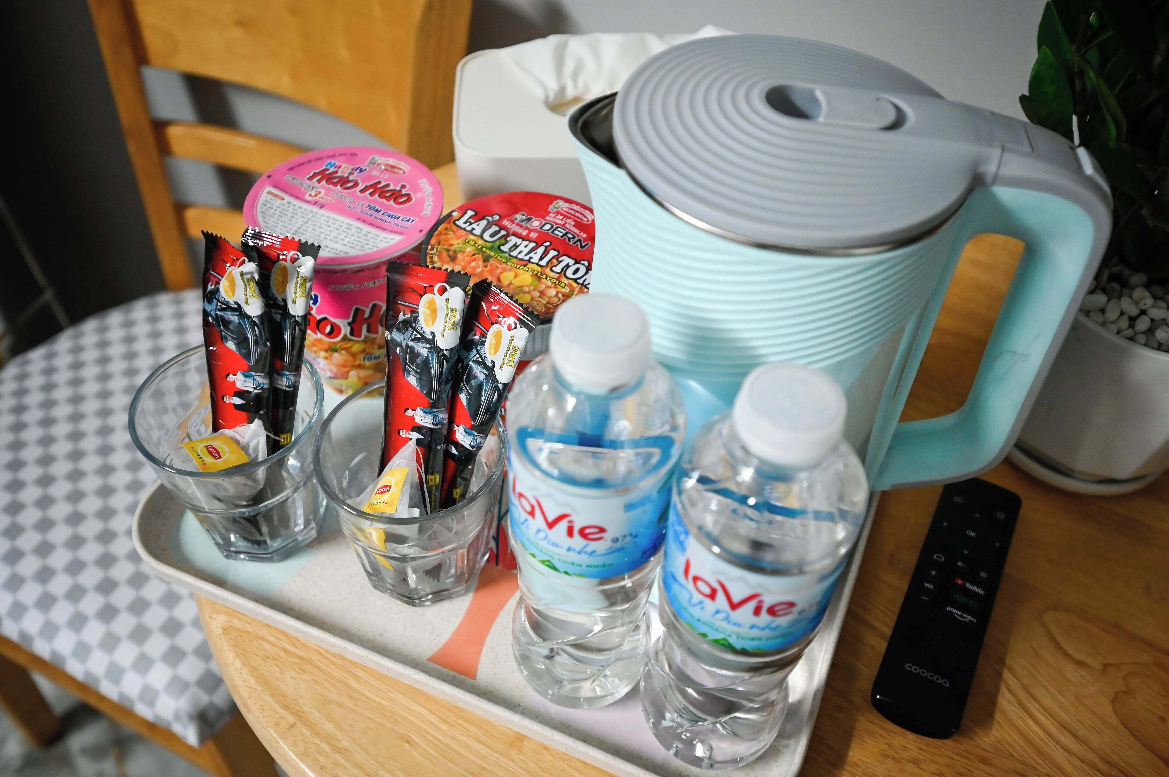 A tray with LaVie water bottles, snacks, and a remote control.
