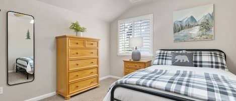 Un dormitorio con cama, cómoda, espejo, ventana y ventilador de techo.