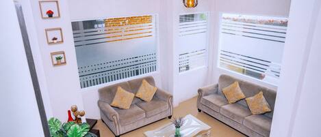 A modern living room with two sofas, a coffee table, and decorative plants.