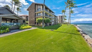 A hotel with a pool, multiple balconies, and a view of the ocean. - Rare LUX Oceanfront Views, Pool, Paradise - Papakea L402 (Lahaina)