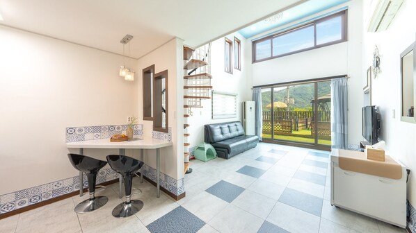 Une cuisine moderne avec un coin repas, un canapé et un balcon offrant une vue agréable.