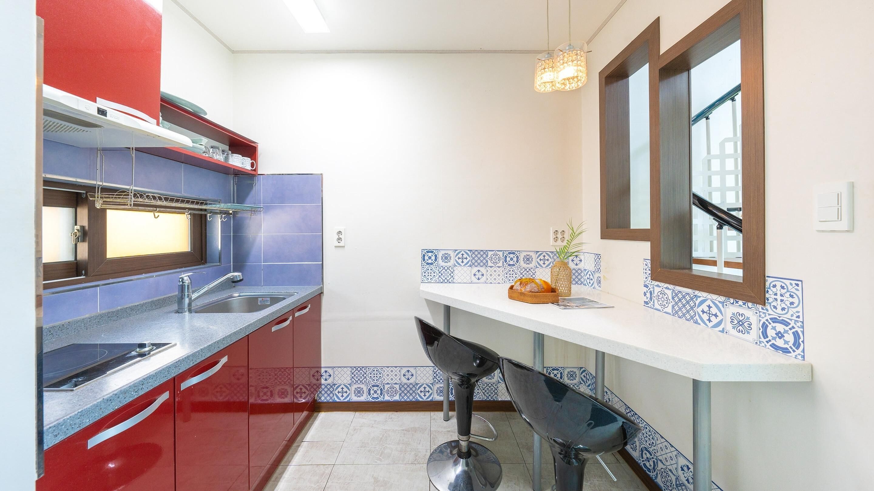 A compact kitchen with a sink, a microwave, and a window above the counter.