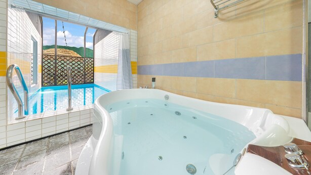 Un bagno con vasca, doccia e vista sulla zona piscina.