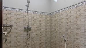 A shower with a wall-mounted showerhead and a handheld showerhead.