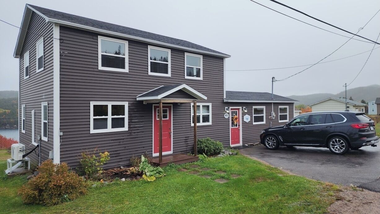 A two-story house with a red door and a garage.