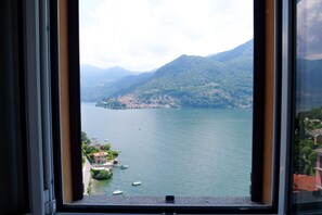 A view of a lake with mountains in the background, a small island, and boats on the water. - Up & Up - MyHomeinComo (Moltrasio)