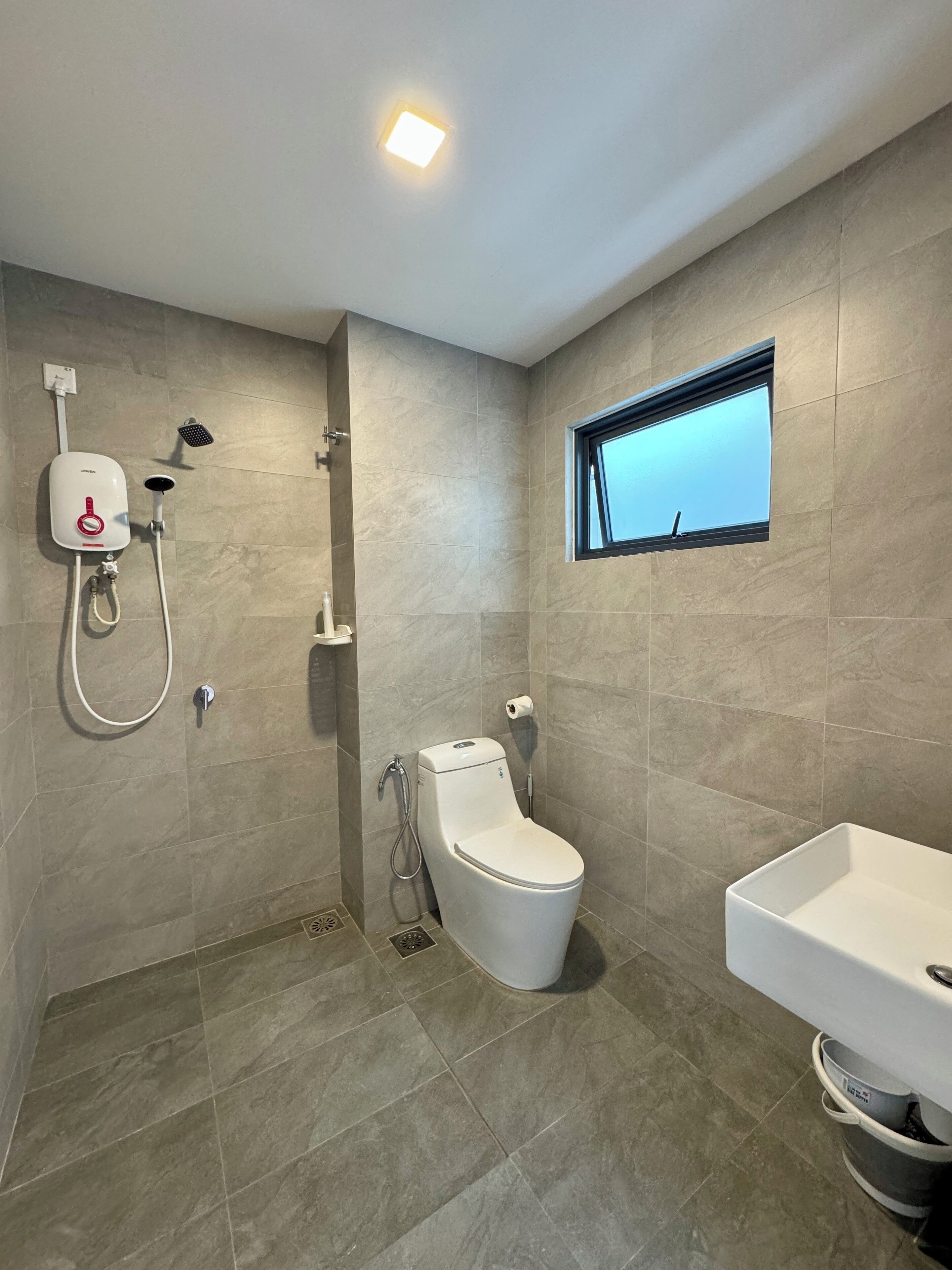 A modern bathroom with a shower, toilet, and sink.