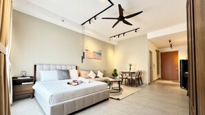 Une chambre d’hôtel moderne dotée d’un grand lit, d’un coin repas et d’un ventilateur de plafond.