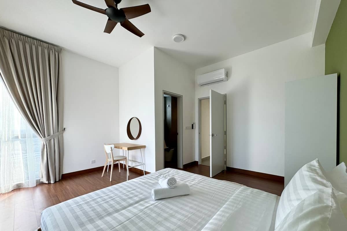 A hotel room with a bed, a desk, and a chair.