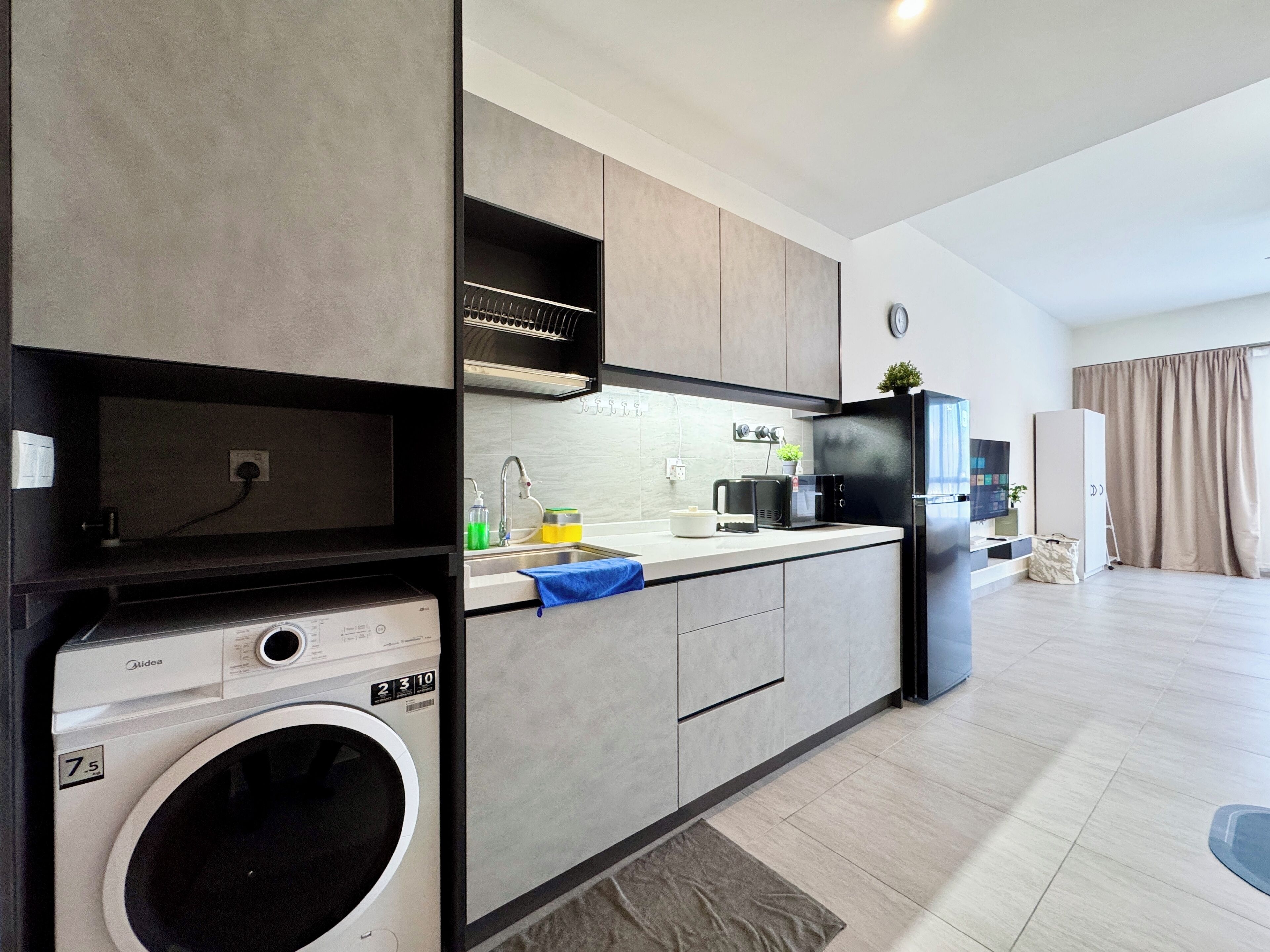 Una cocina moderna con electrodomésticos integrados, una isla grande y una lavadora.