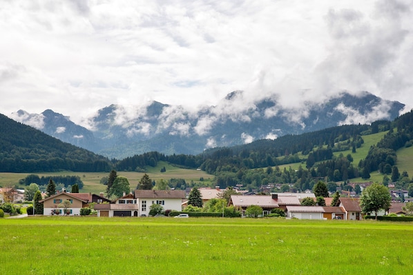 Un pueblo rural con casas y una montaña de fondo.