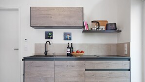Una cocina moderna con encimera de madera, un lavaplatos empotrado y una cafetera.