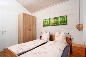 Un dormitorio con cama, armario, mesita de noche y un cuadro en la pared.