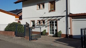 A two-story house with a tiled roof, a garage, and a gated entrance. - Apartment 'Ruth' with Private Terrace and Wi-Fi (Dahn)