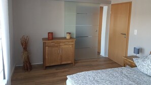 A bedroom with a bed, wooden dresser, and a wardrobe. - Apartment 'Ruth' with Private Terrace and Wi-Fi (Dahn)