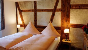 Ein Zimmer mit einem Bett, zwei Nachttischlampen und einem Holzkopfteil.
