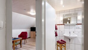 Ein modernes Badezimmer mit Waschbecken, Spiegel und Holzboden.