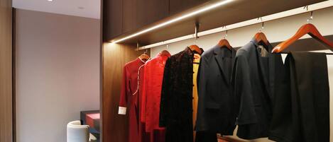 A modern walk-in closet with wooden cabinets and a bench.