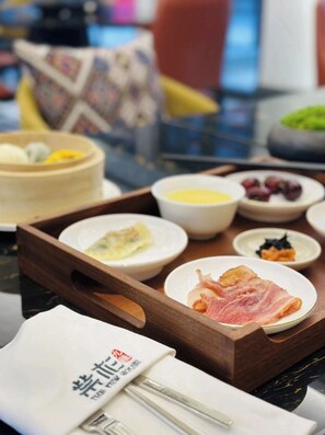 A tray with various food items including eggs, meat, and fruits, suggesting a breakfast setting.