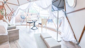 Une tente équipée d’un lit, d’une table, de chaises et d’un téléviseur.