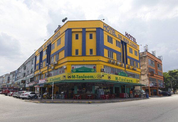 Un edificio en esquina con fachada amarilla y azul, identificado como hotel y restaurante llamado M.Tasleem.