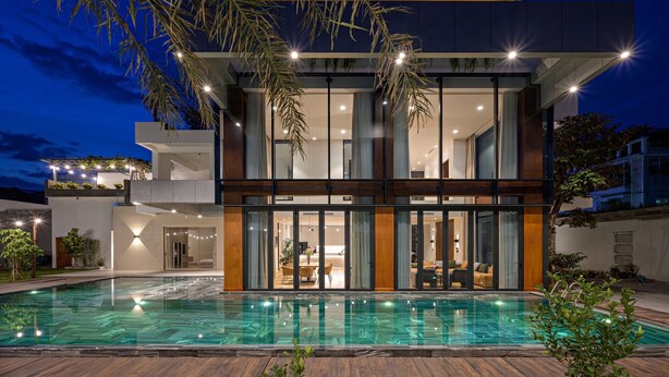 A modern two-story house with a swimming pool, large windows, and outdoor lighting. - Glamorous getaway VILLA in Bien Hoa (Bien Hoa)