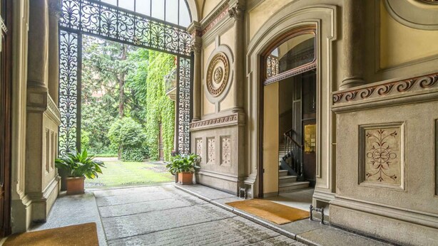 A grand entrance with a wrought iron gate, a stone pathway, and potted plants. - GuestHost - Corso Vittorio Central & Roomy Flat x4 (Torino)