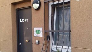 A door labeled 'LOFT' with a security camera above it, a window with a metal grille, and a small sign on the wall. - GuestHost - San Martino / Gaslini Urban Loft x4 (Genova)