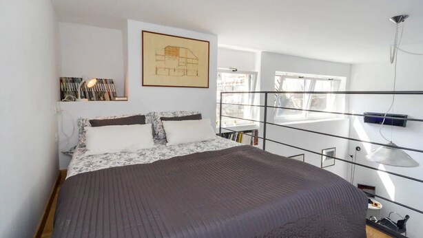 A bedroom with a bed, a framed picture on the wall, a bookshelf, and a window. - GuestHost - San Martino / Gaslini Urban Loft x4 (Genova)