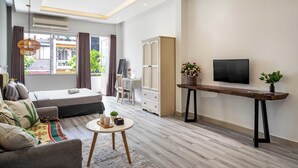 A modern living room with a sofa, a coffee table, a TV, and a wardrobe. - HoLo Ben Thanh Saigon - Serviced HomeStay (Ho Chi Minh City)