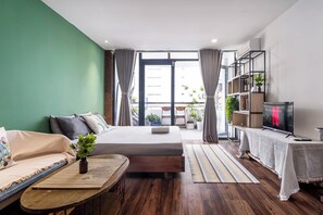 A modern bedroom with a bed, sofa, and a TV.