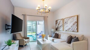 Un salon moderne avec un canapé, une table basse et un téléviseur fixé au mur.