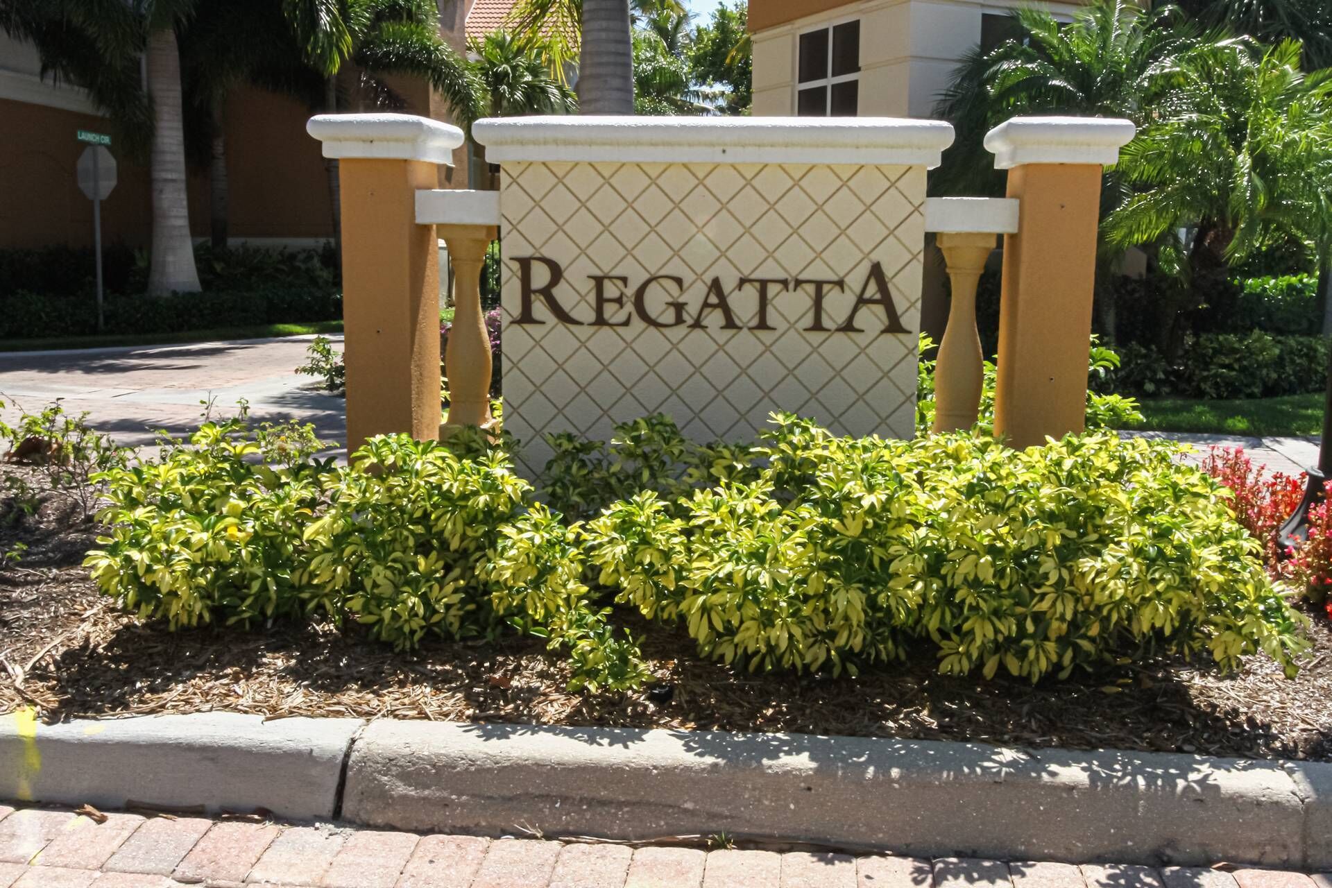 A sign with "REGATTA" in large letters, surrounded by well-maintained bushes and a paved area.
