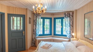 A cozy room with a bed, a bench, and a window with blue shutters. - Villa Sara in Sinaia near Peles & Gondola (Sinaia)