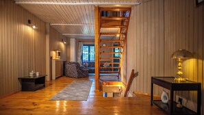 A wooden interior with a staircase, a sofa, and a small table. - Villa Sara in Sinaia near Peles & Gondola (Sinaia)