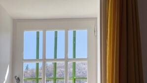 Ein Zimmer mit Fenster, Heizkörper und Bett.