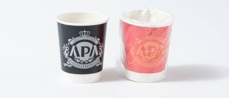 Dos recipientes cilíndricos, uno negro y otro rojo, con las letras "APA" y un emblema de corona.