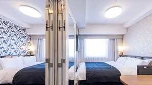 A hotel room with two beds, a wooden table, a patterned carpet, and a large window with curtains. - APA Hotel Hiroshima Ekimae Stadium Guchi (Hiroshima)