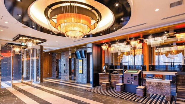 Een hotel lobby met een weelderige kroonluchter, een receptiebalie en een modern design.