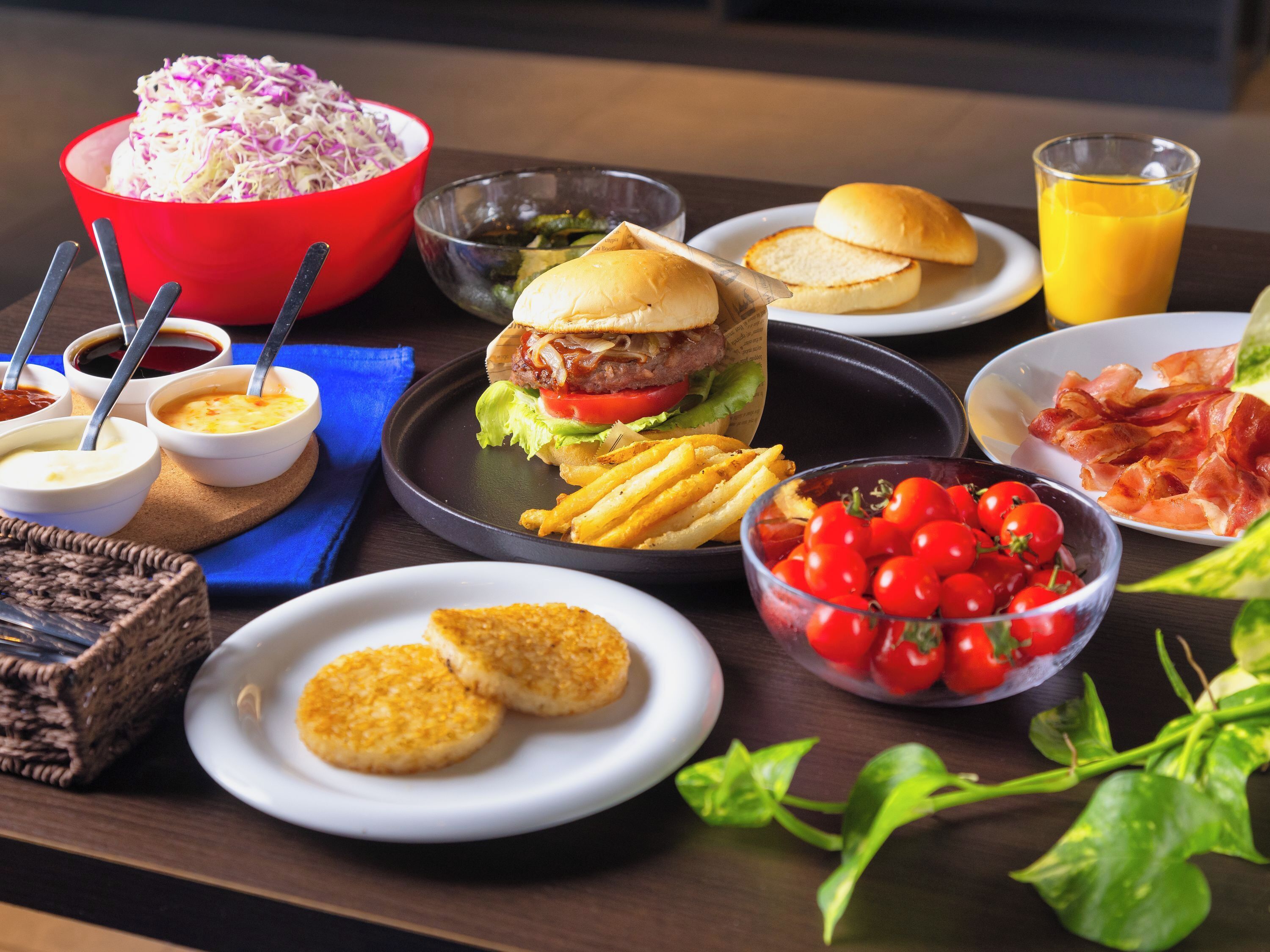A table with a variety of food items including a burger, fries, and a salad.