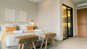 A bedroom with a bed, two side tables, two wicker stools, a nightstand, and a wardrobe. - The Menuai Bali Villas Canggu (Canggu)