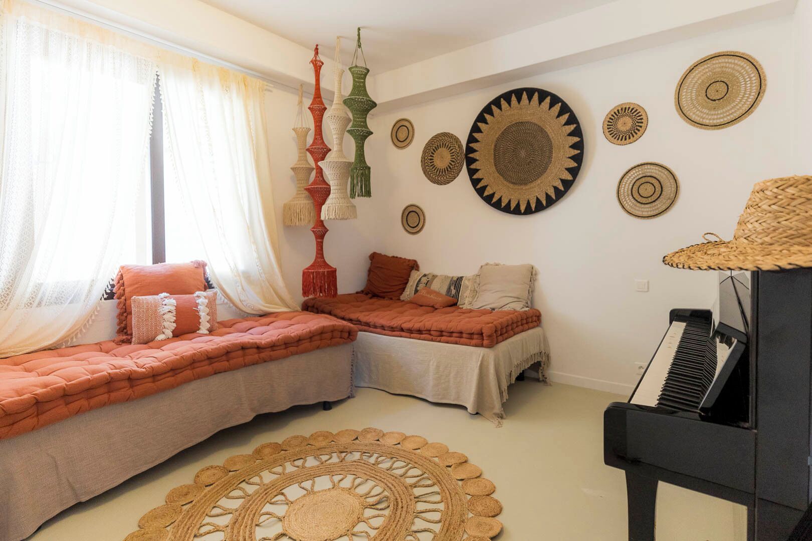 Une pièce chaleureuse avec deux lits, un piano et des éléments décoratifs accrochés aux murs.