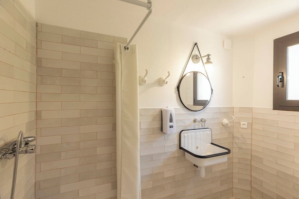 A bathroom with a shower, a sink, a mirror, and a window. - CORSICA HOSTEL PORTO VECCHIO (Porto-Vecchio)