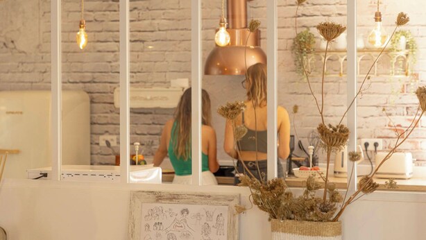 Een moderne keuken met een bakstenen muur, een grote spiegel en hangende lampen.