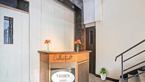 A reception desk with a sign reading "Collection" and "VISHEN RESIDENCY". - Vishen Residency (Greater Noida)