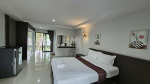A modern hotel room with a large bed, a desk, and a view of the outdoors.