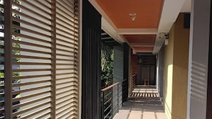A corridor with a wooden slatted wall on one side and a metal railing on the other.